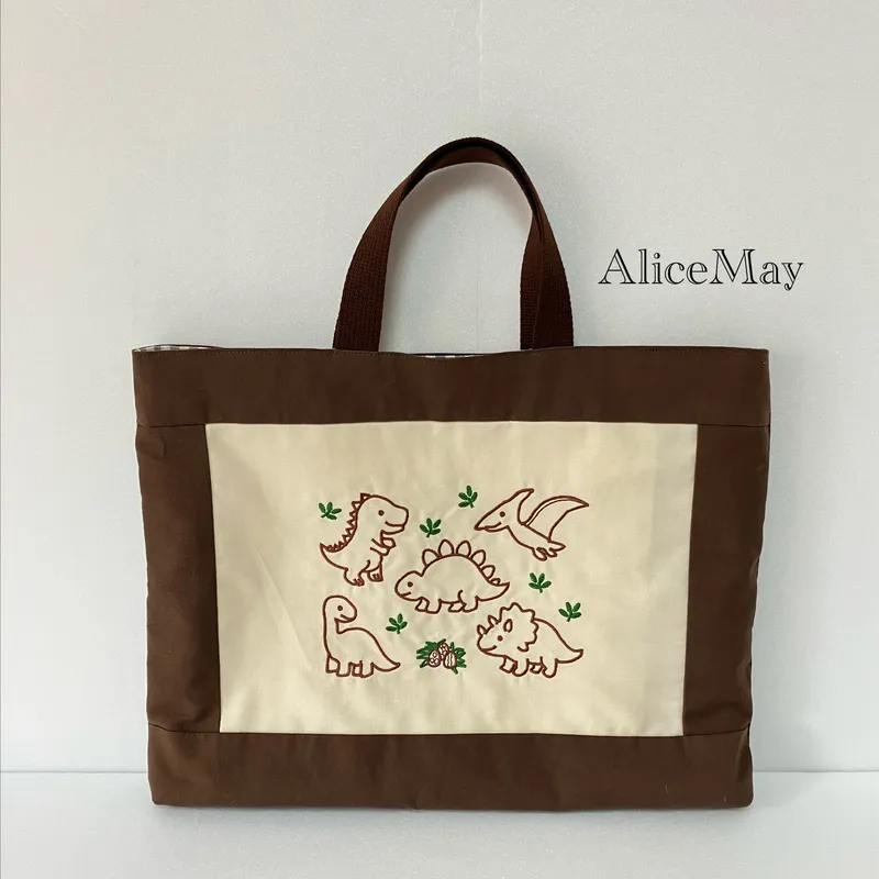 恐竜の刺繍を入れたブラウンのレッスンバッグ